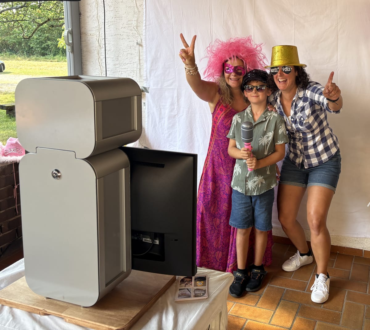 Gäste mit Perücke, Hut und Sonnenbrille neben der Book-the-Box Fotobox