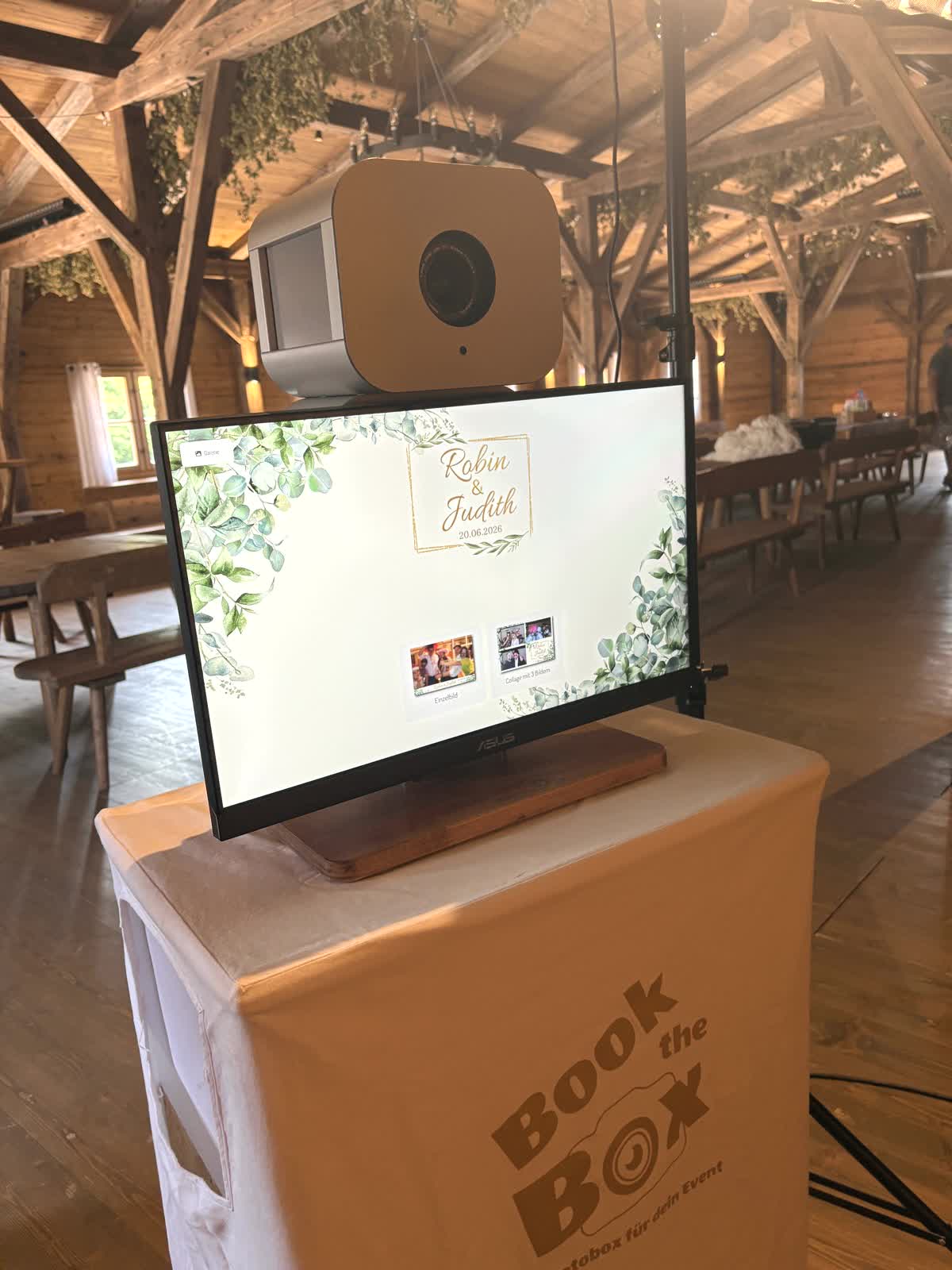 Die Fotobox in einer Scheune, auf dem Touchscreen das Hochzeitslayout mit der Auswahl zwischen Einzelbild und Collage